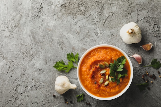 Composition with bowl of pumpkin soup