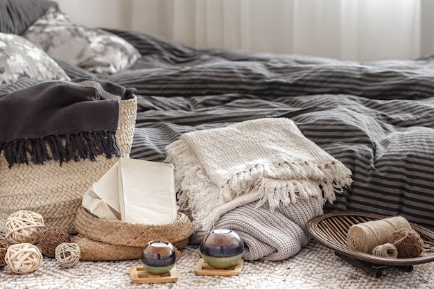 Composition with candles, knitted elements and other decor details in the bedroom.