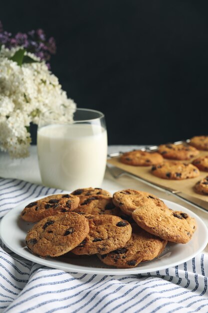 Composition with chip cookies and milk on white table