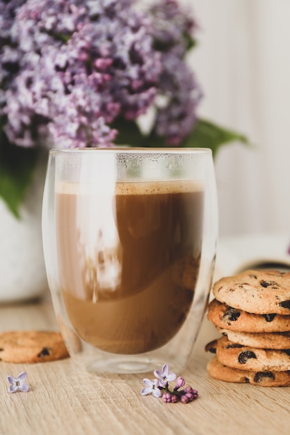 Composition with chocolate chip cookies, cocoa and lilac on wooden table