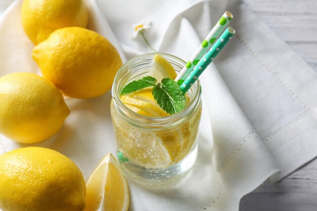 Composition with cold lemon water on wooden table closeup