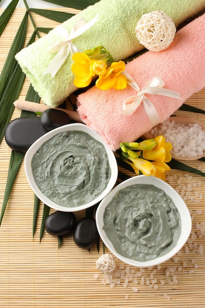 Photo composition with cosmetic clay for spa treatments on bamboo background