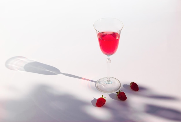 Composition with fresh red juice of strawberries and branch shadow Minimal summer drink concept