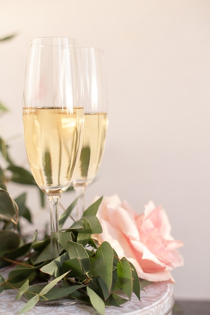 Composition with glasses of vine and flowers on grey concrete background.