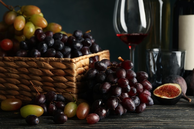 Composition with grape, wine and fig on wooden table