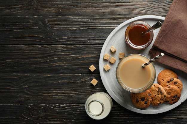 Composition with ice coffee and cookies on wooden background