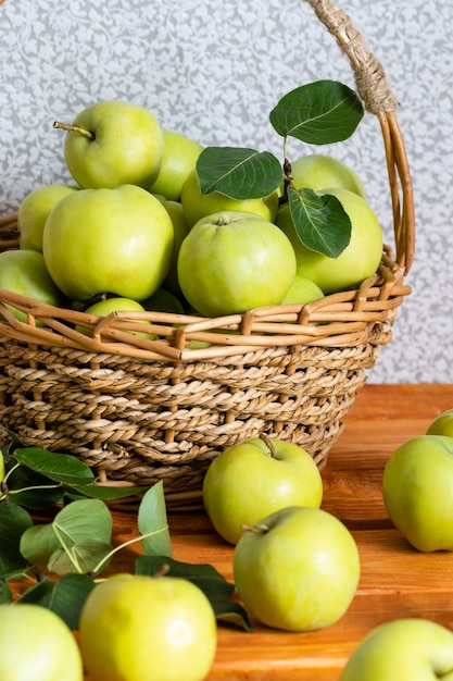 Composition with juicy green apples in wicker basket on table Copy space