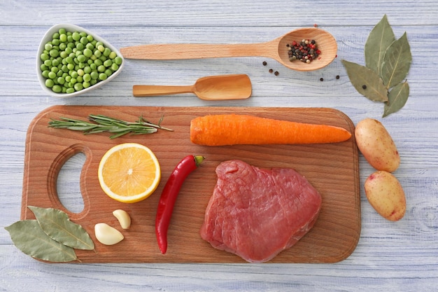 Composition with meat and vegetables on wooden board