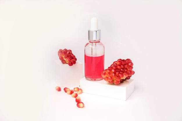 Composition with natural cosmetic oil and pomegranate on light background. High quality photo