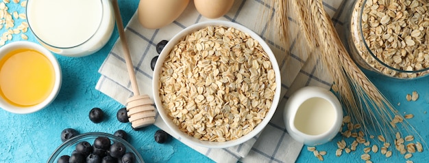 Composition with oatmeal flakes on blue. Cooking breakfast