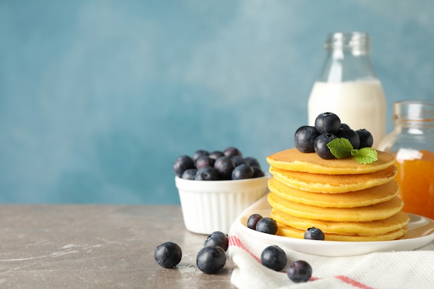 Composition with pancakes and jam on gray table. Sweet breakfast