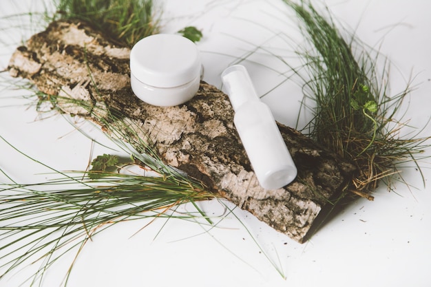 Composition with pipette glass bottle of serum over surface bark tree