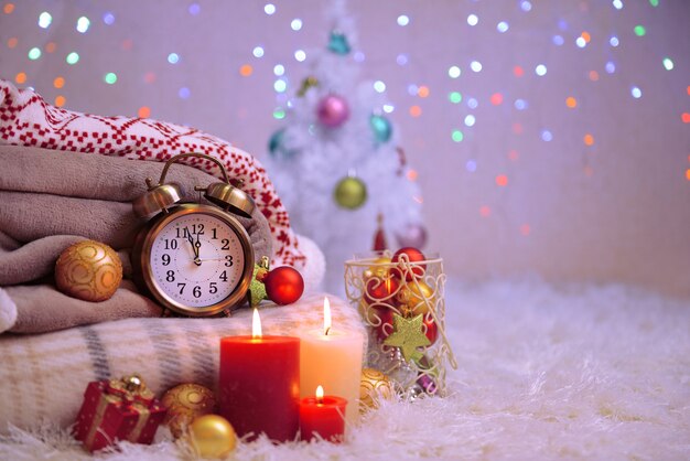 Composition with plaids, candles and Christmas decorations, on white carpet on bright background