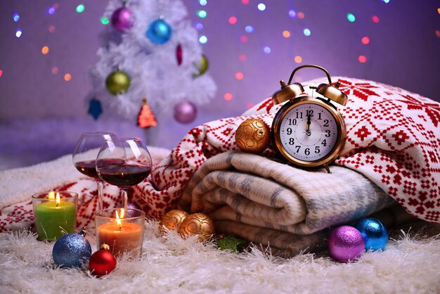 Composition with plaids, candles and Christmas decorations, on white carpet on bright background