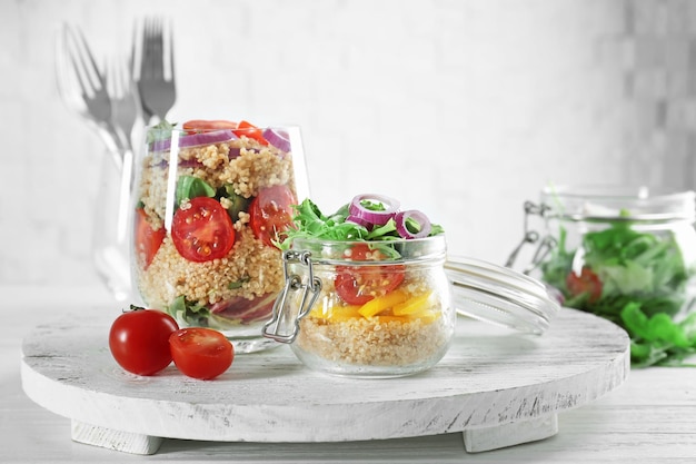 Composition with quinoa and vegetables in glassware on table