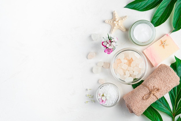 A composition with a spa set flowers and leaves on a light gray background