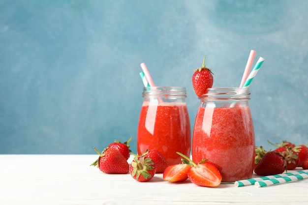 Composition with strawberry cocktails on white wooden table. Summer berry