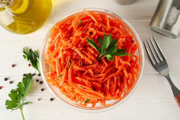 Composition with tasty carrot salad on white wooden background