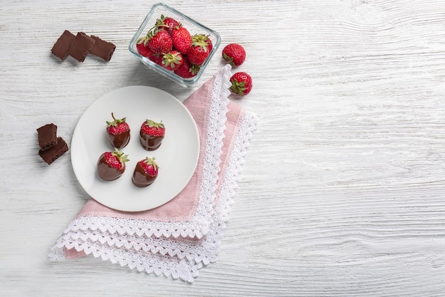 Composition with tasty chocolate covered strawberry on table