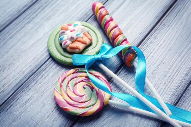 Composition with tasty colorful lollipops on wooden background