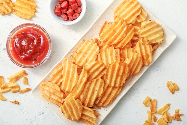 Composition with tasty potato chips on table