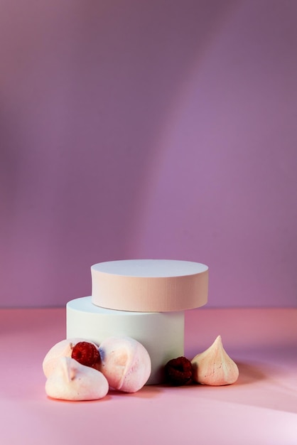 Composition with Three Empty Geometric Podium with Merengue Cookies and Raspberry