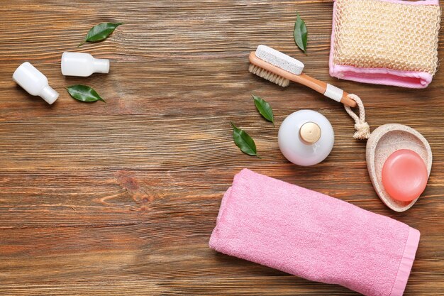 Composition with towel and bath accessories on wooden background