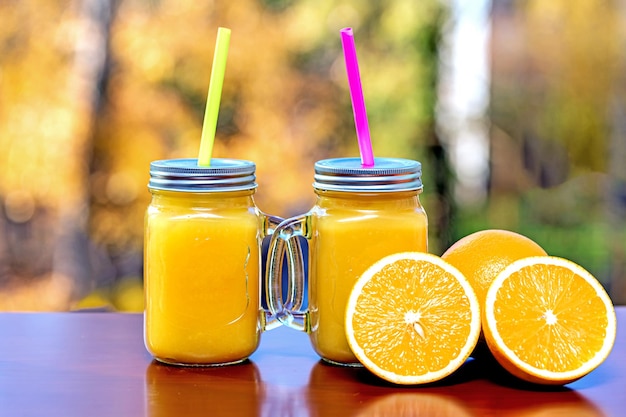 Composition with two glasses of freshly squeezed orange juice and slices of ripe oranges