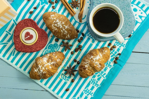 composition on a wooden background with a napkin coffee and croissants top view