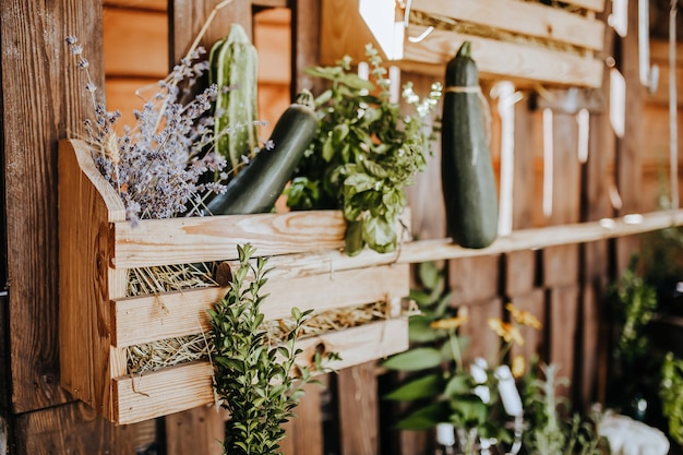 Composition of wooden rustic kitchen table outdoors with decor of lavender plants, vegetables. Country house in summer