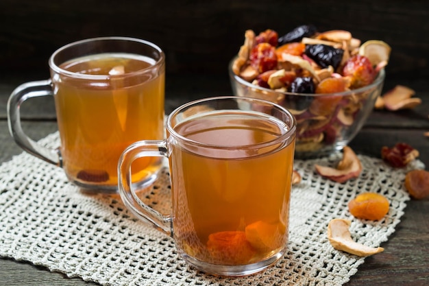 Compote of dried fruits in the mug and assorted dried fruits in bowl