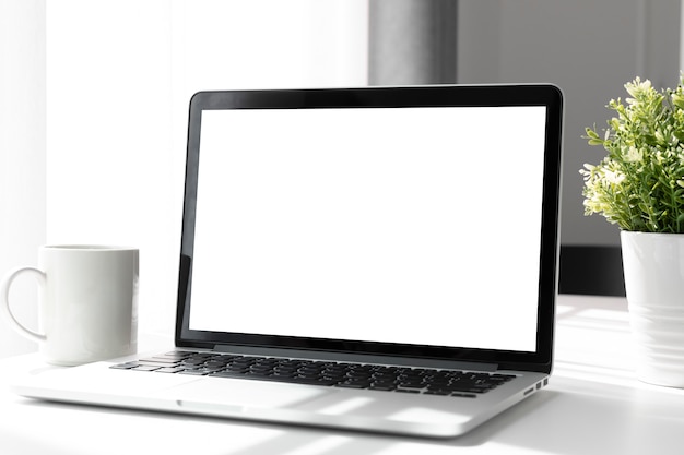 Computer,laptop with blank screen on table home, blurred background.