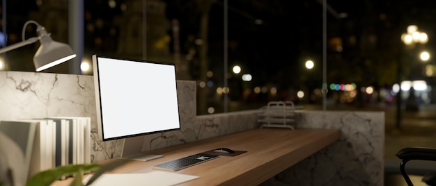 Photo a computer with a whitescreen mockup on a lobby reception counter at night