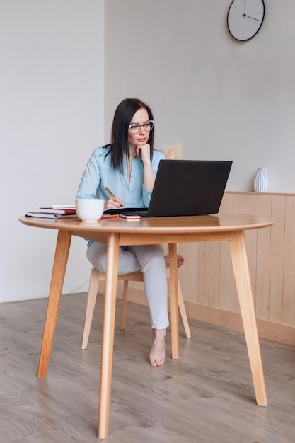 Concentrated beautiful businesswoman working on laptop in modern office