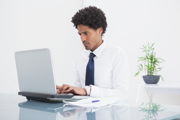 Concentrated businessman using his laptop