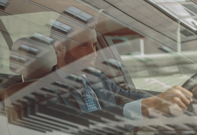 Concentrated confident man in formal clothes traveling by automobile