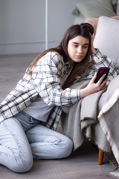 Concentrated girl doing video call on phone using frontal camera for communicating