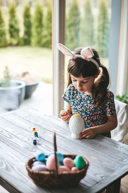 Concentrated girl painting Easter egg