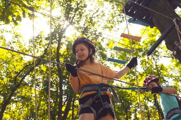 The concentrated kids are climbing in the high rope park