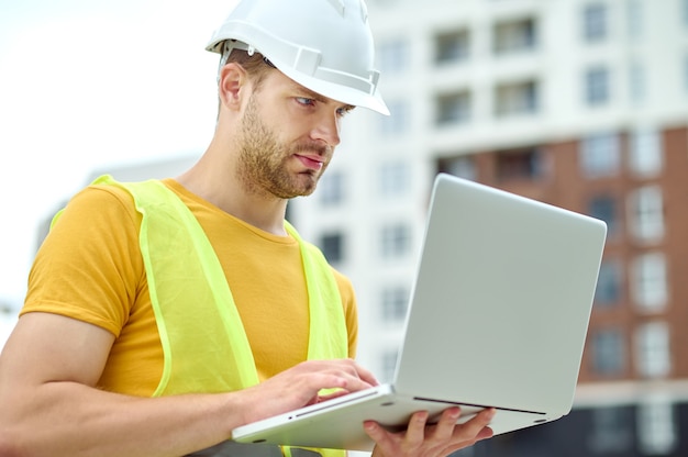 Concentrated male engineer working on his computer outdoors