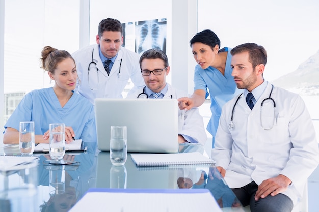 Concentrated medical team using laptop together