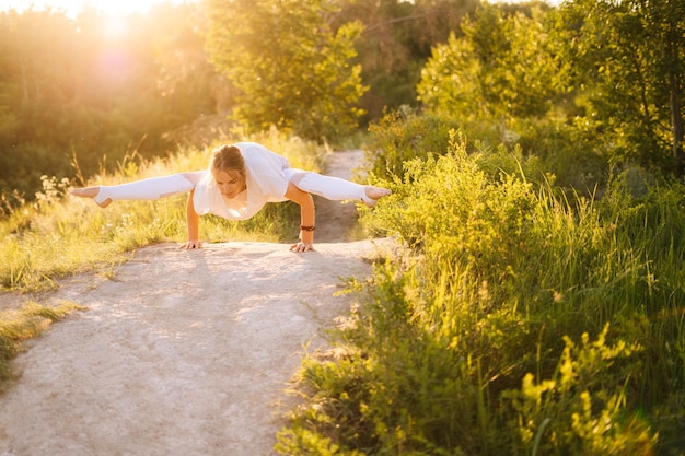 Concentrated sporty woman performing Firefly pose Girl doing yoga exercises leaning on hands