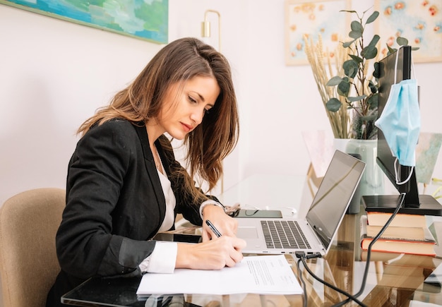 Concentrated woman doing paperwork in home office