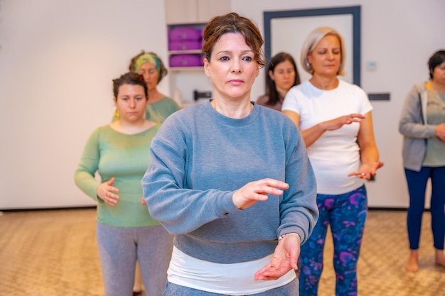 Concentrated women in a qi gong classroom