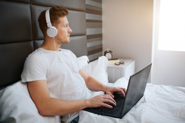 Concentrated young man in bed early morning