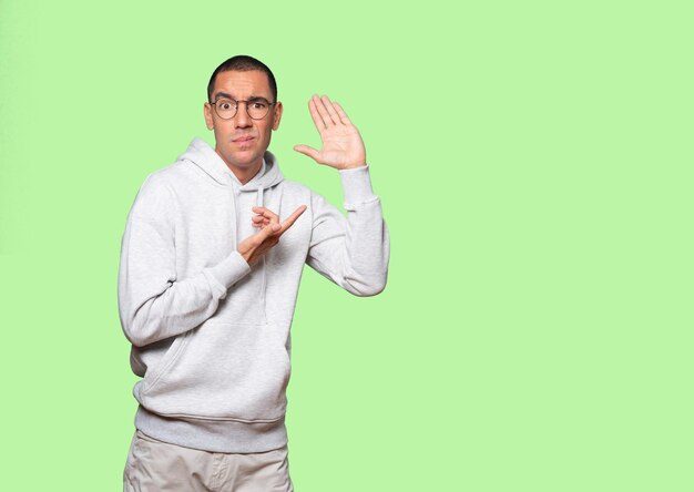 Concentrated young man making a gesture of trying to hear something