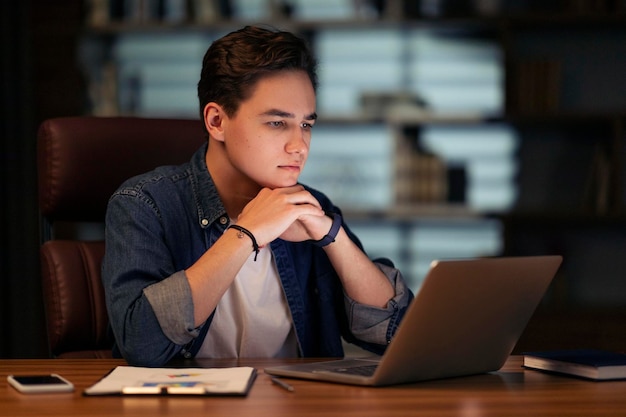 Concentrated young man project manager working at dark office