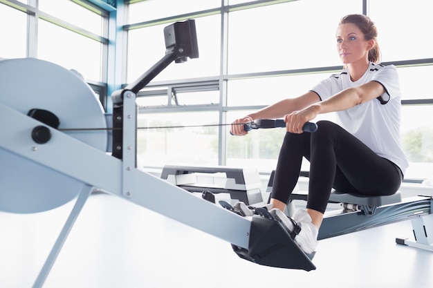 Photo concentrating  woman training on row machine