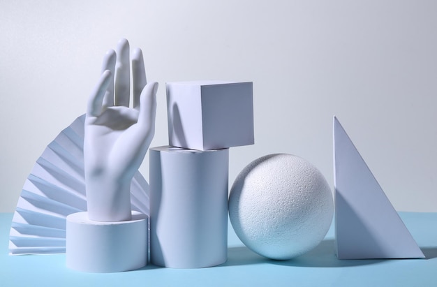 Concept art geometric composition of geometric shapes and a mannequin hand on a bluewhite background Minimalism Showcase