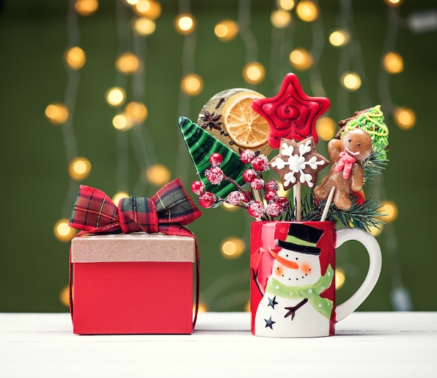 Concept background new year 2022. Christmas gingerbread and candy on sticks and gift boxes. Merry christmas festive background with sweets and decorations